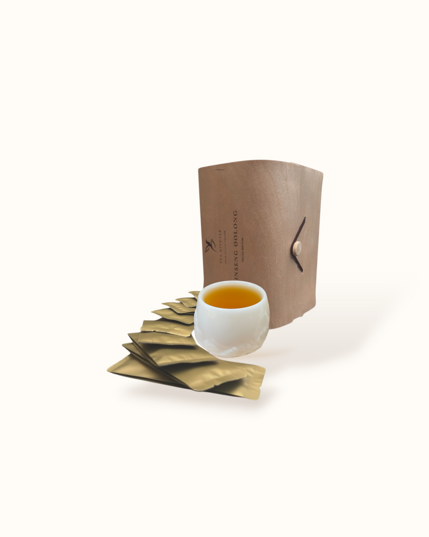 Open Ginseng Oolong tea birch wood tea box with olive-gold sachets and golden tea liquor in a white ceramic tea cup
