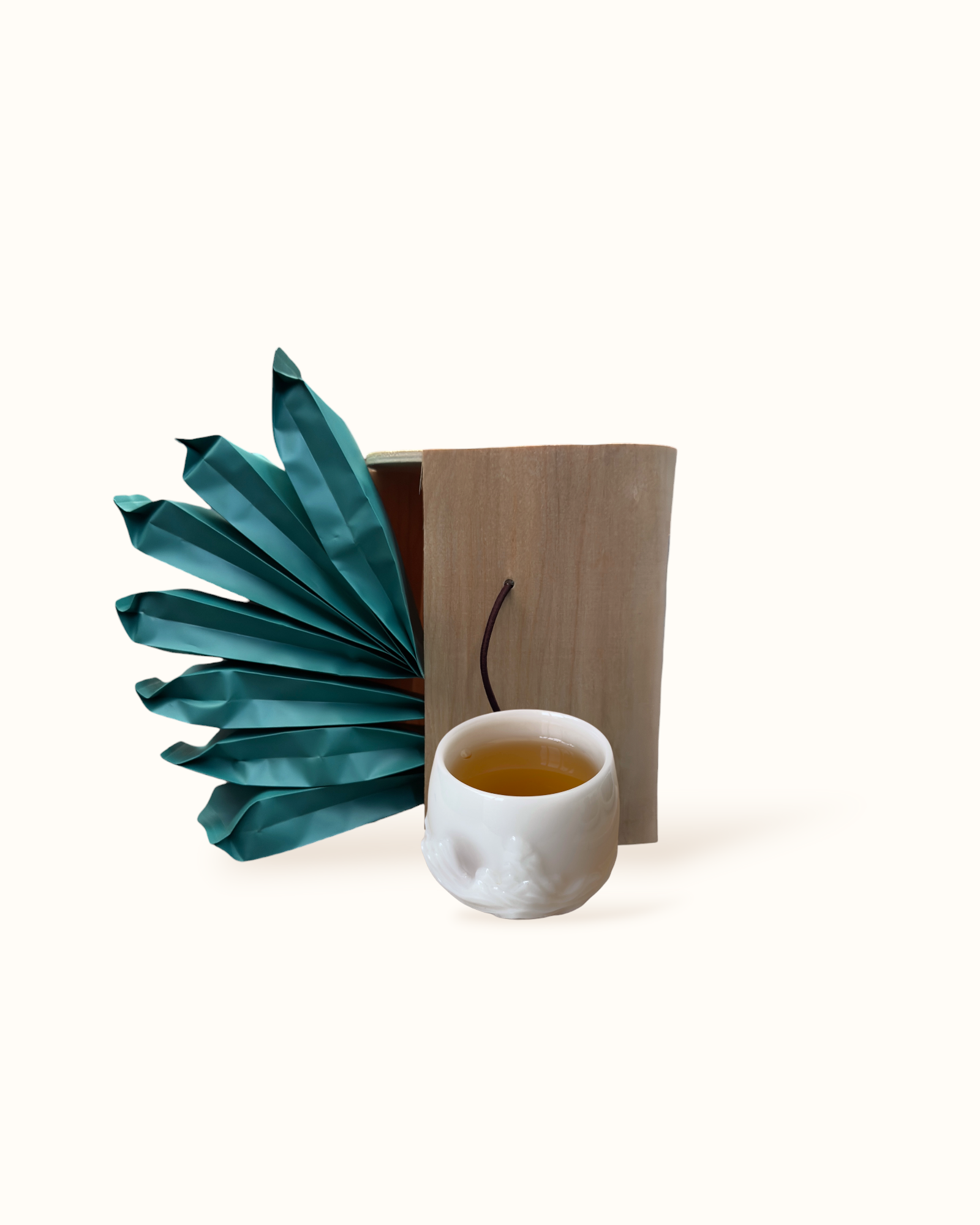 Open White Peony white tea birch wood tea box with teal sachets and amber-golden tea liquor in a white ceramic tea cup
